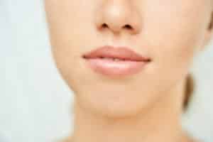 A close up of the bottom of a young woman's face showing her full lips