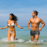 couple laughing together in the ocean waves.
