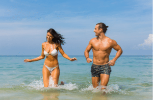 couple laughing together in the ocean waves.